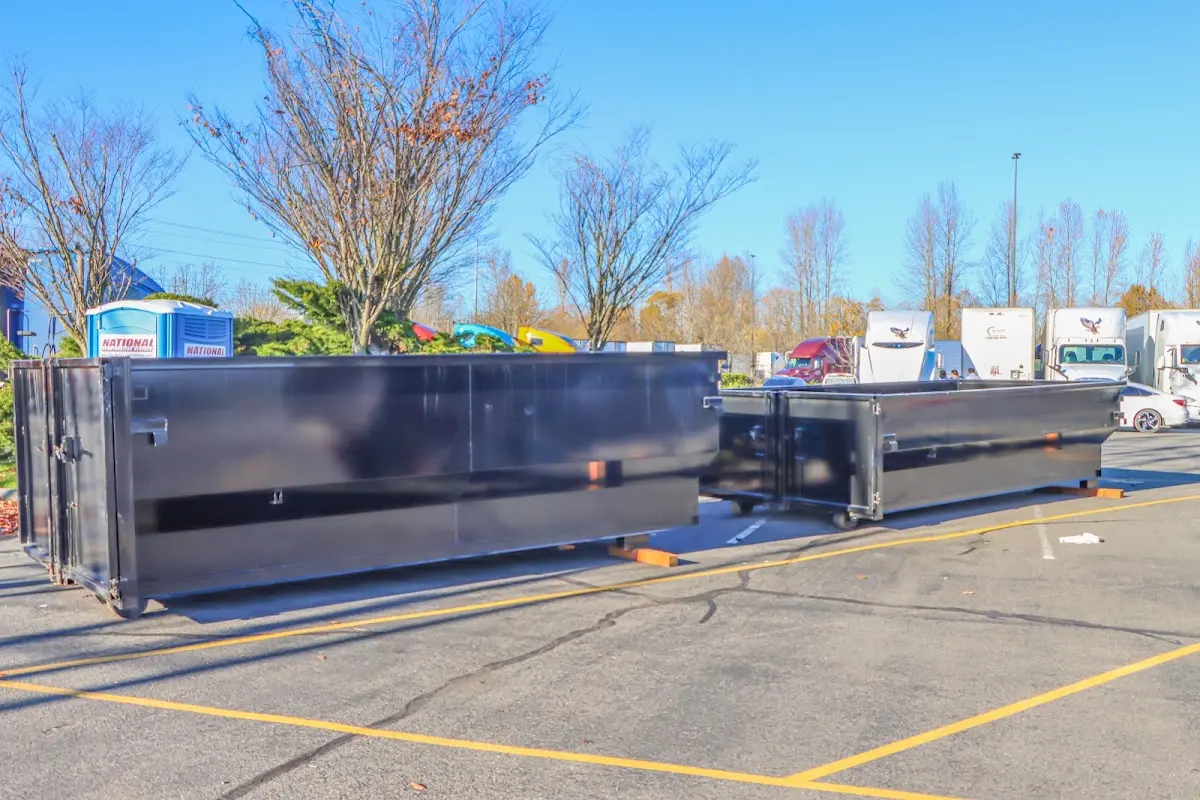 Professional dumpster rental service with roll-off container on residential driveway in Paramount